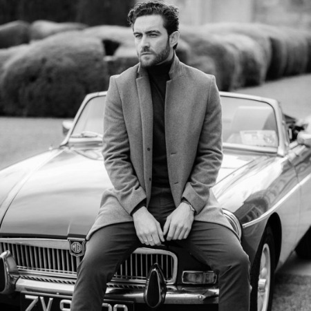 Laurence O'Fuarain posing with his luxurious classic car MG MGB.